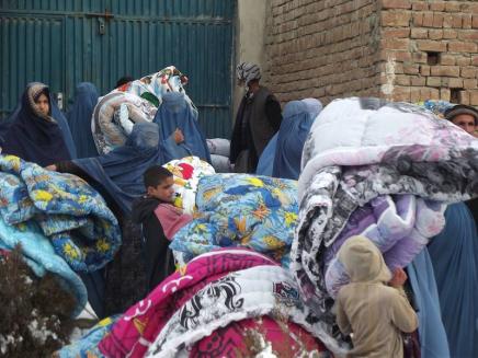 Distributing duvets in a refugee camp