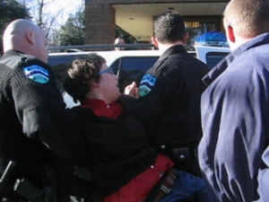 Tamara Tal, student at UNC-Chapel Hill, is carried out of Price’s office by the police.
