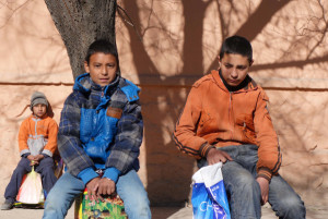 Sabrullah, Mehdi, and Suhairulla sit on rice sacks